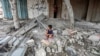 (FILE) A Palestinian boy sits at the site of an Israeli strike on a house, amid the Israel-Hamas conflict, in Maghazi refugee camp in the central Gaza Strip, August 14, 2024.