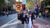 Sepasang suami istri berbaris saat parade Hari Anzac di pusat kawasan bisnis Sydney, Australia, Kamis, 25 April 2024. (AP/Mark Baker)