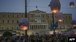 Protesters in Athens release hot air balloons in front of the Greek parliament on June 15, 2023, as a tribute to the victims during a demonstration to protest against the EU and Greek government's policies following a deadly shipwreck that killed at least 78 migrants.