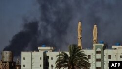 FILE: Smoke billows above buildings in southern Khartoum amid ongoing fighting between the forces of two rival generals, on May 16, 2023. One month since Sudan's conflict erupted, its capital is a desolate war zone.