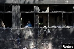 A man uses his mobile phone to take pictures inside a Radio Pakistan office building after it was set afire by the supporters of Pakistan's former Prime Minister Imran Khan during a protest against his arrest, in Peshawar, Pakistan, May 11, 2023. REUTERS/Fayaz Aziz