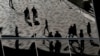 FILE - Workers are reflected in an office building's windows in Sydney's Barangaroo business district in Australia's largest city, May 8, 2017. Millions of Australians can now break free from the stress of after-hours calls and emails from work.