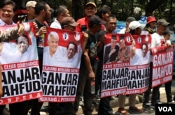 Ratusan pendukung calon presiden Ganjar Pranowo dan Calon Wakil Presiden Mahfud MD melakukan aksi dukungan di depan Kantor Pusat PDIP pada Rabu (18/10) di Jakarta. (VOA/Indra Yoga)