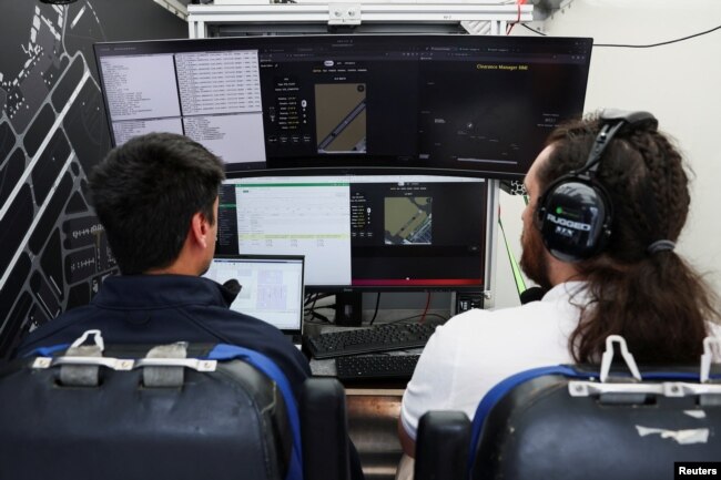 Engineers work on computers on the flight test engineer station at the back of the Airbus Upnext flying truck. (REUTERS/Stephanie Lecocq)