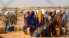 Des femmes et des enfants déplacés par la sécheresse vont chercher de l'eau dans un point de distribution proche du site de Farburo pour personnes déplacées à Gode, dans la région Somali de l'Éthiopie, le 27 janvier 2018.