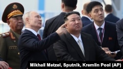 ປະ​ທາ​ນາ​ທິ​ບໍ​ດີ ຣັດ​ເຊຍ ທ່ານ ວ​ລາ​ດິ​ເມຍ ປູ​ຕິນ, ຊ້າຍ ແລະ ຜູ້​ນຳ​ ເກົາຫຼີ​ເໜືອ ທ່ານ ກິມ ຈົງ​ ອຶນ ກວດ​ກາ​ຖານ​ປ່ອຍ​ຍານ​ອະ​ວະ​ກາດ ຢູ່​ສະ​ຖານ​ທີ່​ປ່ອຍ​ຍານ​ອະ​ວະ​ກາດ ວອ​ສ​ໂຕ​ຈ​ນີ. (Mikhail Metzel, Sputnik, Kremlin Pool Photo via AP)