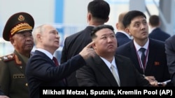 Presiden Rusia Vladimir Putin dan pemimpin Korea Utara Kim Jong-un memeriksa landasan peluncuran di kosmodrom Vostochny, sekitar 200 kilometer dari Blagoveshchensk, Rusia, 13 September 2023. (Mikhail Metzel, Sputnik, Kremlin Pool Photo via AP)