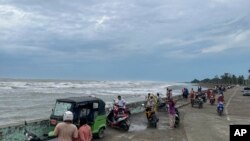 Locals stand on the bank of sea before Cyclone Mocha hits, in Sittwe, Rakhine State, May 13, 2023. Bangladesh and Myanmar are bracing for a severe cyclone.