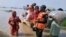 In this photo released by Rescue 1122 Emergency Department, rescue workers evacuate villagers through a boat from a flooded area of Bahawalnagar district in Pakistan's Punjab province, Aug. 23, 2023.