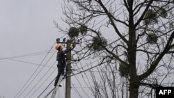 Seorang pekerja memperbaiki jaringan listrik setelah serangan Rusia di desa Velyka Vilshanytsia, sekitar 50 kilometer dari kota Lviv, Kamis 9 Maret 2023.