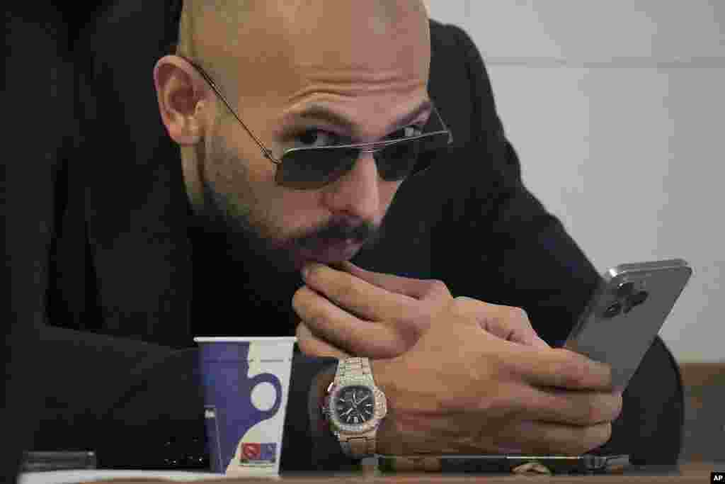 Andrew Tate checks his mobile phone inside the Court of Appeal building in Bucharest, Romania.