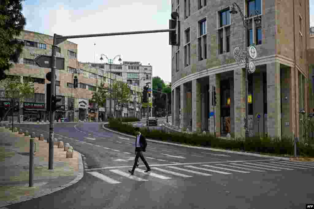 A man crosses an empty street in Jerusalem, April 14, 2024.&nbsp;Iran&#39;s unprecedented attack on Israel has been &quot;foiled,&quot; the Israeli army announced, with almost all of the more than 200 missiles and drones intercepted with the help of the United States and allies.&nbsp;