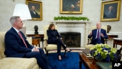 Speaker of the House Kevin McCarthy of California, left, and Vice President Kamala Harris, middle, listen to U.S. President Joe Biden during debt ceiling talks at the White House, May 16, 2023, in Washington. Biden has canceled trips abroad next week to continue the talks.