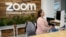 FILE - A woman works at Zoom headquarters on Feb. 3, 2023, in San Jose, California. Zoom is asking employees who live within a 50-mile radius of its offices to work onsite two days a week.