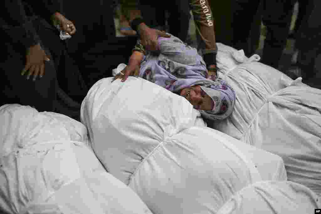 Palestinians mourn over the bodies of relatives killed in an Israeli airstrike, outside the morgue in Al-Aqsa Martyrs Hospital in Deir al Balah, the Gaza Strip.