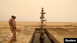 Seorang pekerja tampak berjalan melewati sumur minyak di ladang minyak Sindbad di dekat perbatasan antara Iran dan Irak di Basra, Irak, pada 23 April 2018. (Foto: Reuters/Essam Al-Sudani)