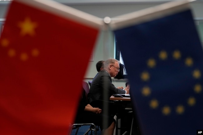 Jens Eskelund, president of the European Chamber is framed by the Chinese and European Union flags during the launch of the European Business in China: Business Confidence Survey in Beijing, Wednesday, June 21, 2023. Foreign companies are shifting investments and their Asian headquarters out of China as confidence plunges following the expansion of an anti-spying law and other challenges, the business group said Wednesday. (AP Photo/Ng Han Guan)