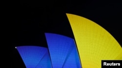 FILE - The sails of the Sydney Opera House get illuminated with the colors of the Ukrainian Flag to mark one year since Russia's invasion of Ukraine began, in Sydney, Feb. 24, 2023. More than 11,000 Ukrainians have come to Australia since Russia invaded in Feb. 2022.