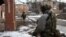 Ukrainian servicemen walk along a street in the front line city of Bakhmut, in Ukraine's Donetsk region, Feb. 9, 2023.