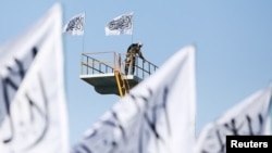 FILE - A Taliban fighter is seen at the Taliban flag-raising ceremony in Kabul, Afghanistan, March 31, 2022. 