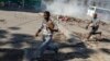 Hombres corren a refugiarse mientras la policía antidisturbios lanza gases lacrimógenos en un esfuerzo por dispersar a la gente cerca del Palacio Nacional, en Puerto Príncipe, Haití, el martes 2 de abril de 2024.[Foto: Archivo/AP].