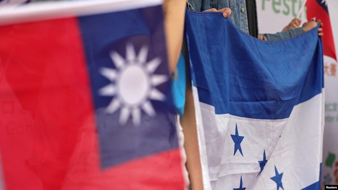 Orang-orang mengibarkan bendera nasional Honduras dan Taiwan selama unjuk rasa untuk mendukung hubungan antara Taiwan dan Honduras, di kampus Universitas Nasional Taiwan, di Taipei, Taiwan, 25 Maret 2023. (Foto: Reuters)