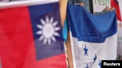 Orang-orang mengibarkan bendera nasional Honduras dan Taiwan selama unjuk rasa untuk mendukung hubungan antara Taiwan dan Honduras, di kampus Universitas Nasional Taiwan, di Taipei, Taiwan, 25 Maret 2023. (Foto: Reuters)