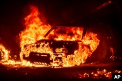 Flames consume a vehicle as the Park Fire burns in Tehama County, California, July 26, 2024. 