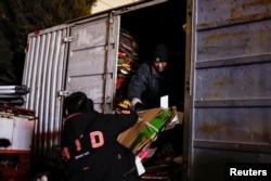 Wu Yonghou, 58, loads cardboards onto a truck at a recycling station in Beijing, China January 31, 2024. (Tingshu Wang)