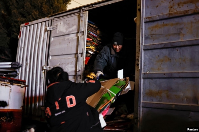 Wu Yonghou, 58, loads cardboards onto a truck at a recycling station in Beijing, China January 31, 2024. (Tingshu Wang)