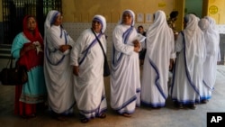 Las monjas de las Misioneras de la Caridad, la orden fundada por la Madre Teresa, hacen cola para emitir su voto durante la última ronda de una elección nacional de seis semanas de duración, en Calcuta, India, el 1 de junio de 2024.
