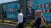 People pass by one of the many campaign billboards that can be seen all over Istanbul, on May 8, 2023. (Yan Boechat/VOA)
