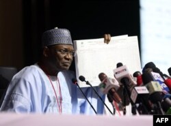 FILE - The chairman of Independent National Electoral Commission, Yakubu Mahmood, displays a results sheet to the media during the presentation of final results of Nigeria's general and presidential election, in Abuja, Feb. 27, 2023,