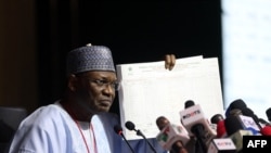 The Chairman of Independent National Electoral Commission, Yakubu Mahmood, displays a results sheet to the media during the presentation of final results of Nigeria's General and Presidential election, in Abuja, Feb. 27, 2023,