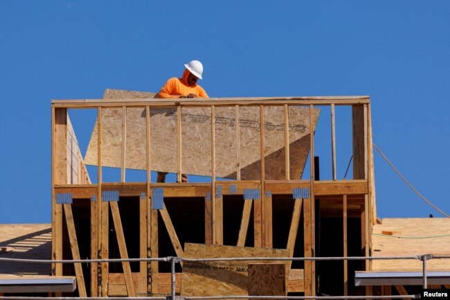 FILE - A worker helps construct a residential homes in Vista, California, Oct. 24, 2023.
