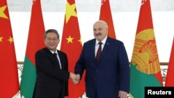 Belarusian President Alexander Lukashenko shakes hands with China's Premier Li Qiang during a meeting in Minsk, Belarus, Aug. 22, 2024, in this photo from the Press Service of the President of the Republic of Belarus.