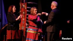 Minnesota Governor Tim Walz fist bumps Lieutenant Governor Peggy Flanagan during the governor's inauguration at the Fitzgerald Theater in St. Paul, Minn., Jan. 7, 2019.