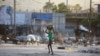 ARCHIVO: Una mujer cruza una calle después de choques entre la policía y hombres armados en el vecindario de Portail, en Puerto Príncipe, Haití, el 29 de febrero de 2024.