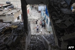 Palestinians asses the damage following an Israeli strike in the Nuseirat refugee camp in the central Gaza Strip, July 6, 2024.