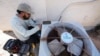 FILE - Total Refrigeration service tech Michael Villa works on replacing a fan motor on an air conditioner as temperatures were expected to hit 42.7 Celsius (117 Fahrenheit), July 19, 2023, in Phoenix, Arizona.
