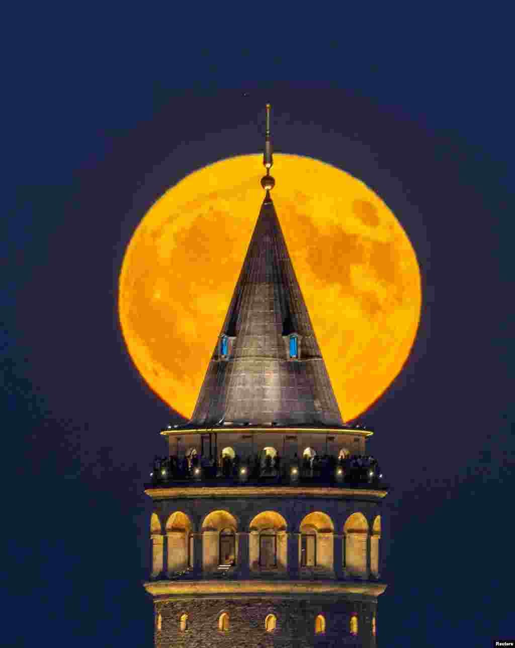 A supermoon, known as the blue moon, rises over the historical Galata Tower in Istanbul, Turkey, Aug. 19, 2024.