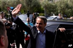 Perdana Menteri Yunani dan pemimpin Demokrasi Baru Kyriakos Mitsotakis menyapa para pendukungnya usai pemungutan suara di sebuah tempat pemungutan suara di Athena, 21 Mei 2023. (Foto: AP)