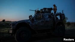 Un militar ucraniano se encuentra en un vehículo Oshkosh M-ATV protegido contra emboscadas resistente a minas (MRAP) durante un simulacro militar cerca de una línea del frente, en la región de Donetsk, Ucrania, el 13 de junio de 2024. 