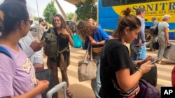 French nationals gather as they wait to be airlifted back to France on a French military aircraft, at the international airport in Niamey, Aug. 1, 2023. 