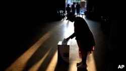 A woman casts her ballot at a polling station during general elections in Eshowe, South Africa, May 29, 2024. 