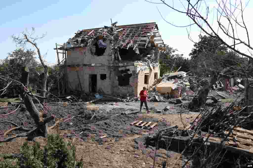 Човек поминува покрај уништена куќа по ракетен напад во регионот Киев, Украина.