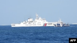 This photo released by the Philippine Bureau of Fisheries and Aquatic Resources on March 25, 2024, shows a Chinese Coast Guard ship blocking a Philippine ship near Thitu Island, in the Spratly Islands, in the disputed South China Sea.