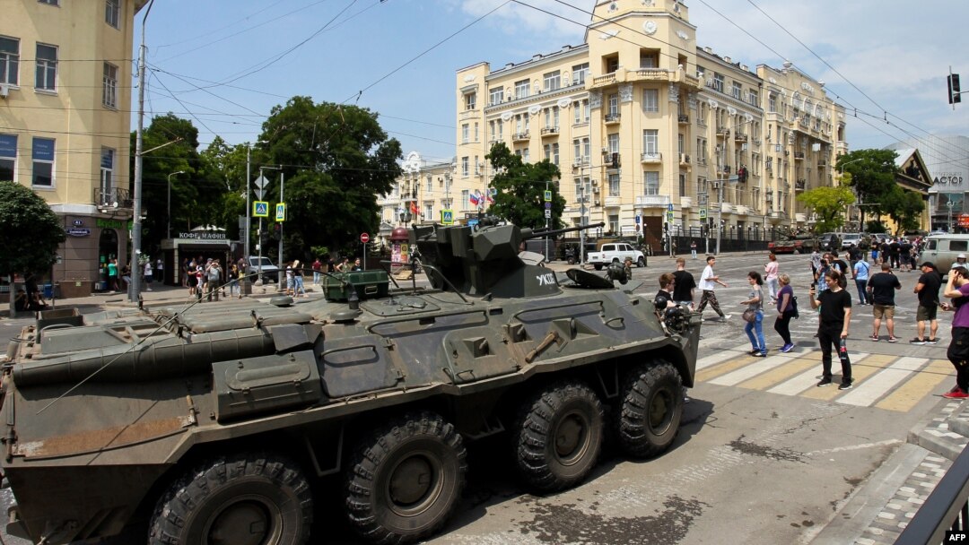 Orang-orang berjalan melewati pengangkut personel lapis baja di Kota Rostov-on-Don, pada 24 Juni 2023. (Foto: AFP)