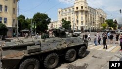 Orang-orang berjalan melewati pengangkut personel lapis baja di Kota Rostov-on-Don, pada 24 Juni 2023. (Foto: AFP)