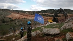 Para tentara pasukan perdamaian PBB mengibarkan bendera PBB sambil mengamati alat berat Israel menghancurkan terowongan dekat perbatasan selatan Lebanon-Israel di desa Mays al-Jabal, Lebanon, 13 Desember 2019. (Foto: Hussein Malla/AP Photo)